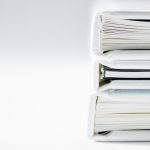 Stack of white binders on a white backdrop