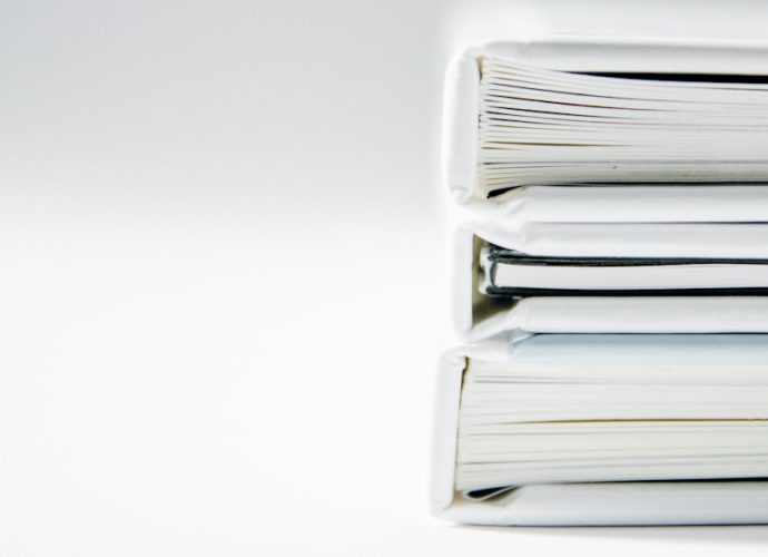 Stack of white binders on a white backdrop