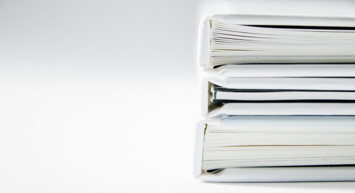 Stack of white binders on a white backdrop