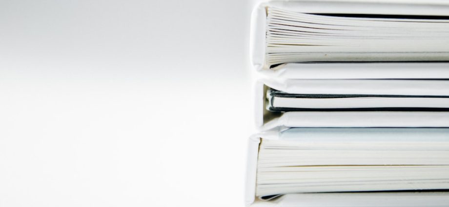 Stack of white binders on a white backdrop