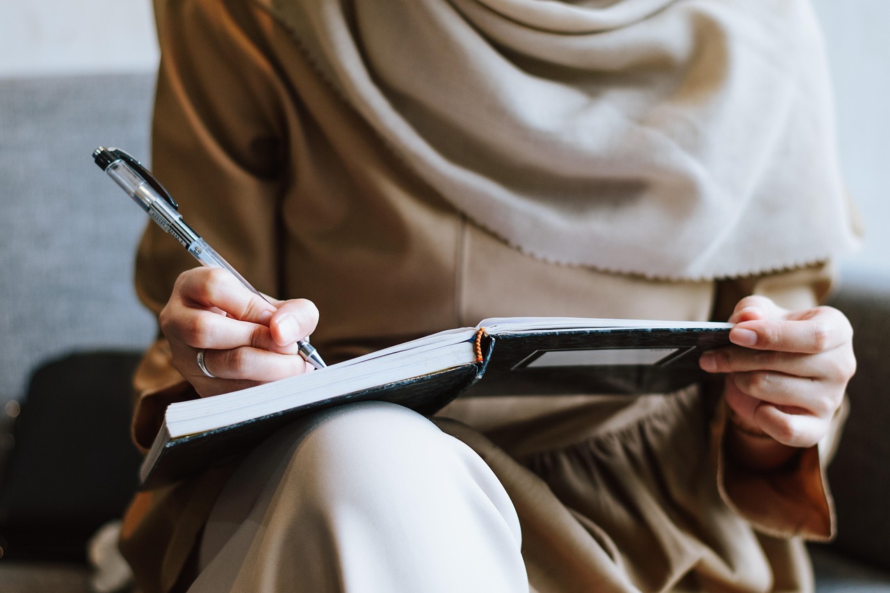 Muslim, woman, writing — How selling your insurance agency can benefit from professional valuation and expert advisory suppor